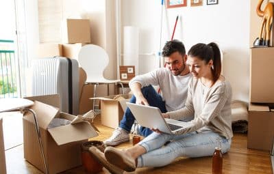 Couple sur ordinateur pendant déménagement