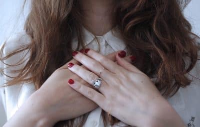 Femme mains croisées bague argent