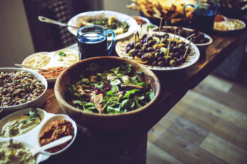 Buffet de plusieurs spécialités apéritives disposées dans des plats sur une table en bois